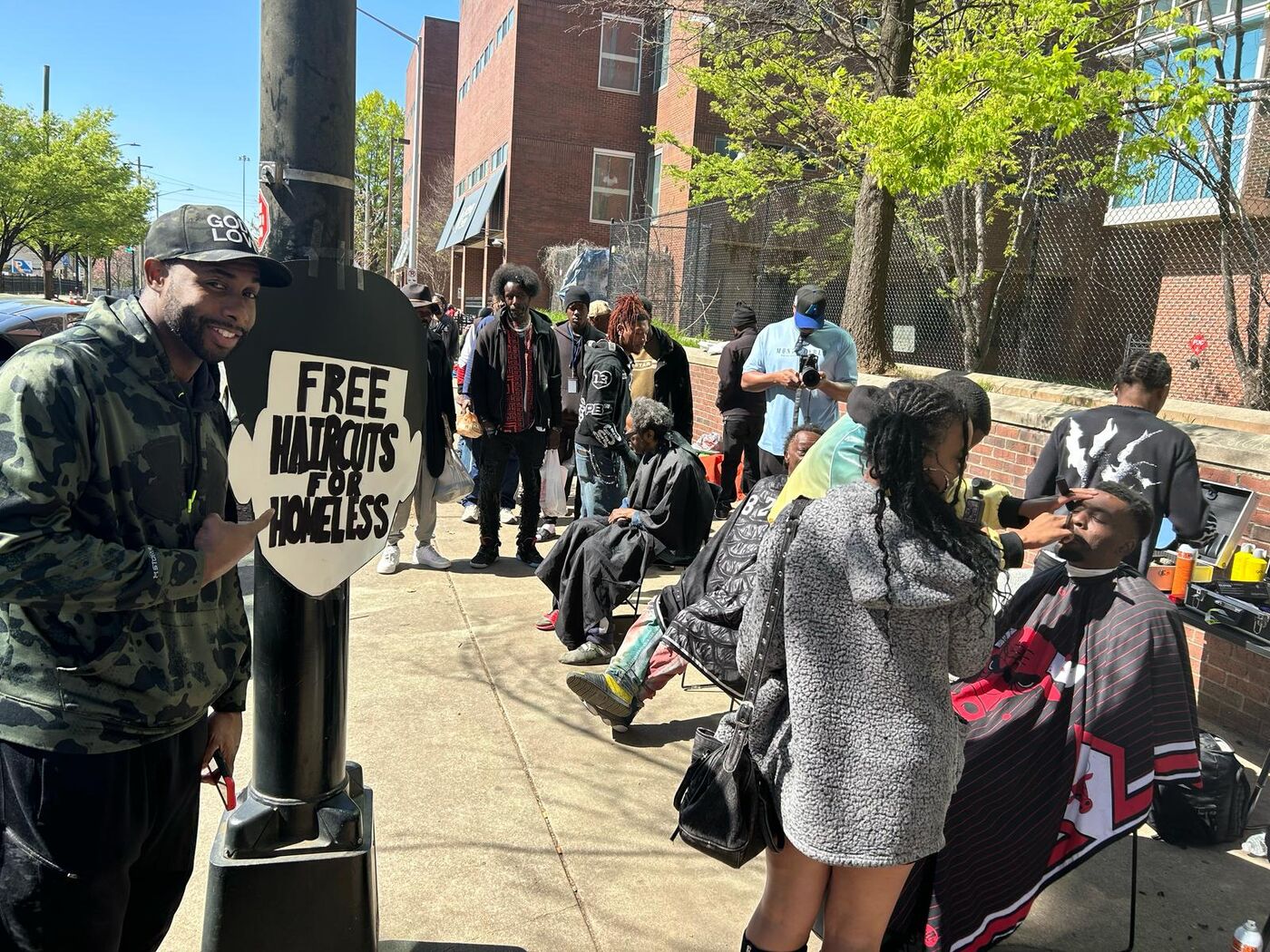 Free haircuts for the homeless sign at a street outreach event