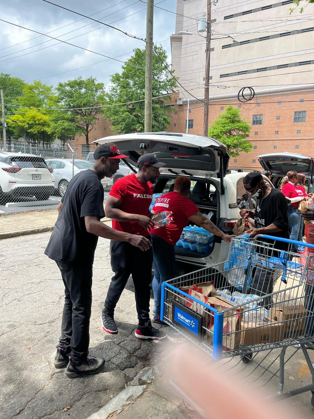 Volunteer wheeling a cart of supplies into an outreach event