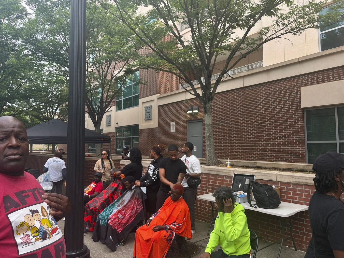 Wide view of multiple barber chairs going at once at an outreach event