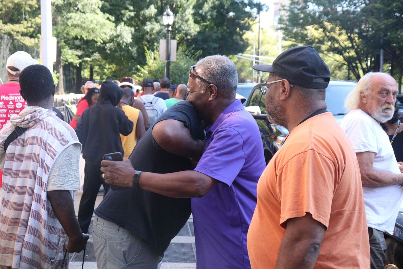 Volunteers and neighbors embracing at a community event